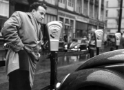 Ein Autofahrer sucht im Jahr 1954 in Hamburg nach einem Parkgroschen.